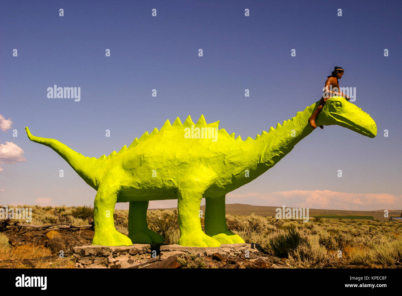 Statue de dinosaure vert géant avec une Indienne Shoshone perché sur son cou est une attraction touristique à la grotte de glace dans la région de Shoshone, Idaho. Banque D'Images
