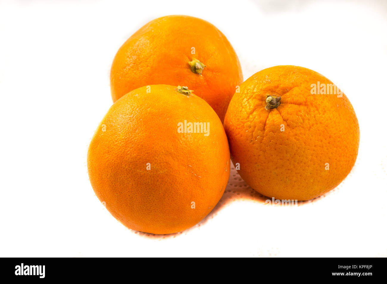 Trois oranges sur papier à fond blanc Banque D'Images