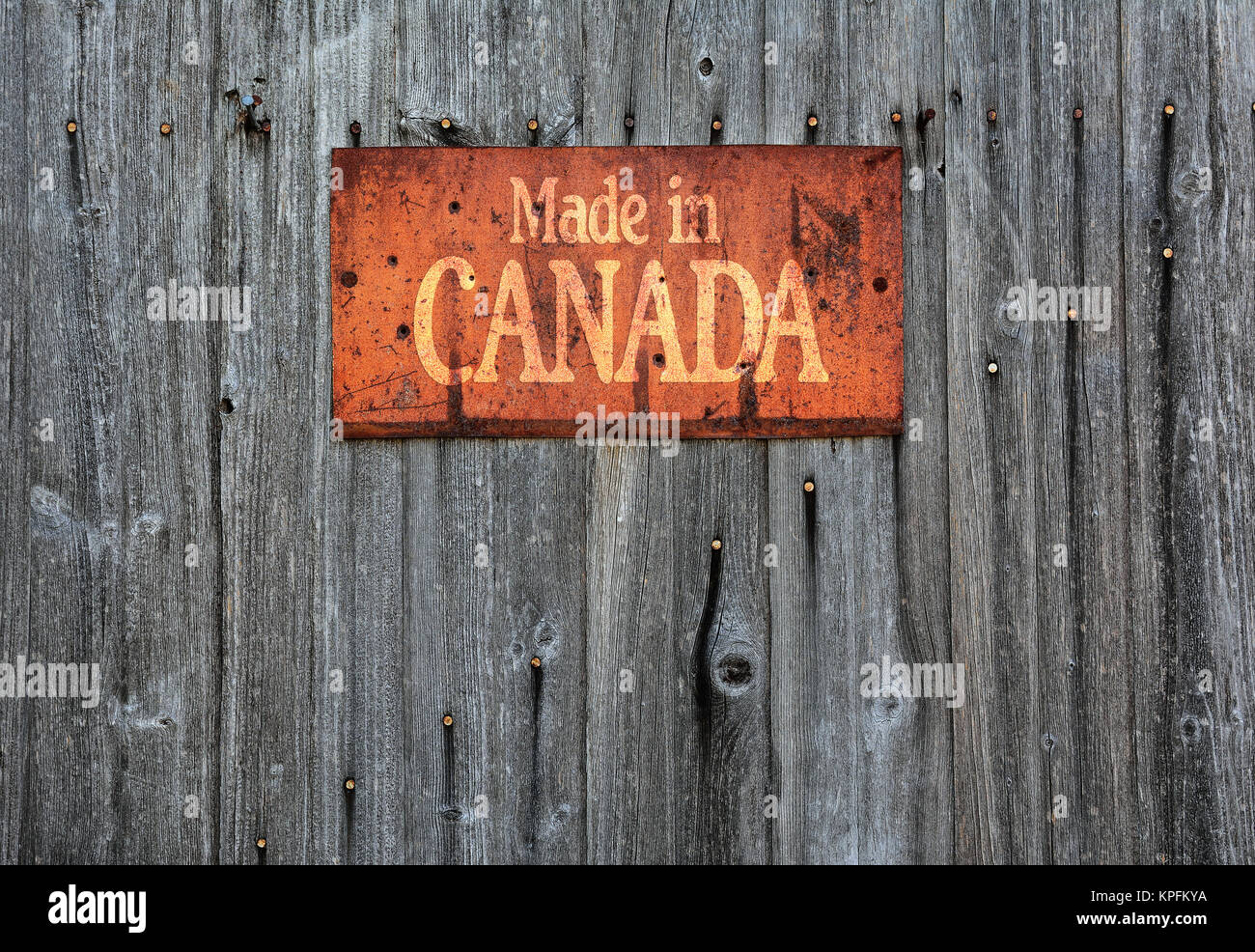 Rusty metal sign sur mur en bois avec la phrase : fabriqué au Canada. Banque D'Images