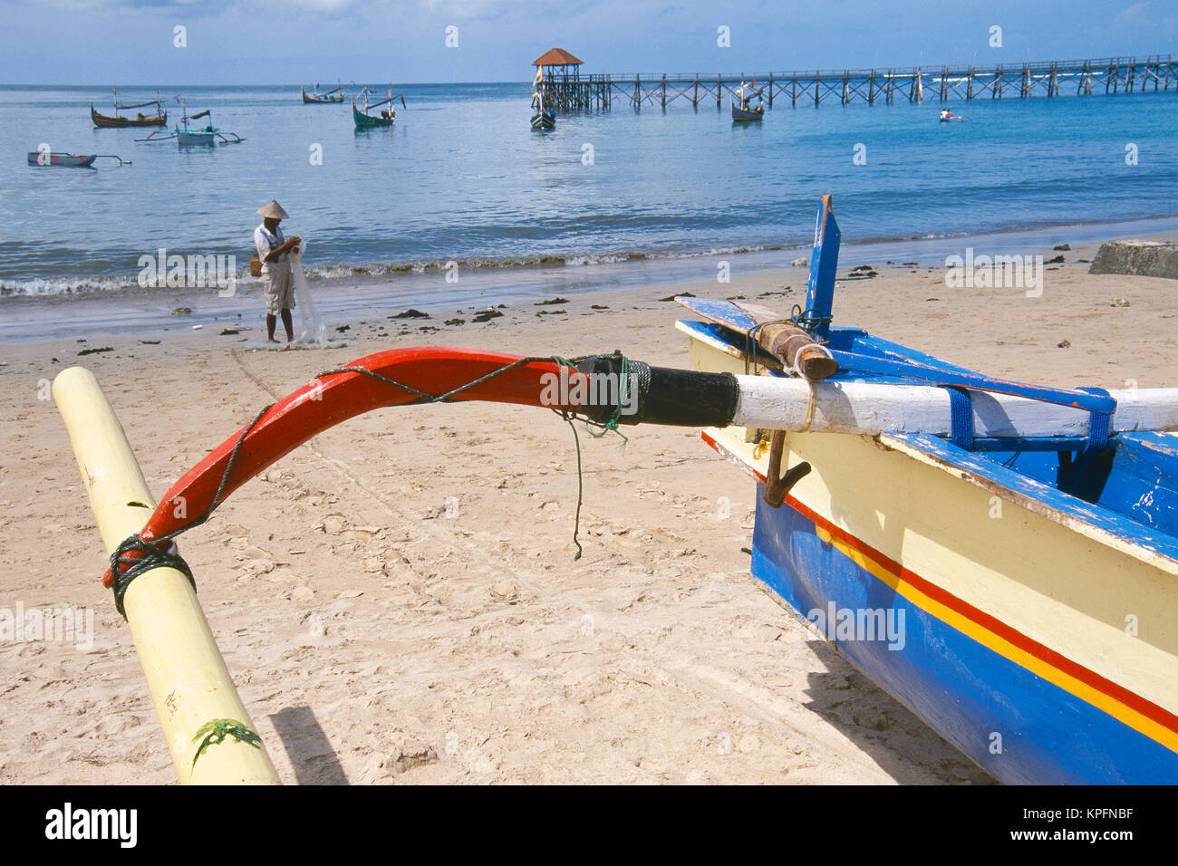 L'Asie, INDONÉSIE, Bali, Jimbaran et village de pêcheurs. Jukungs colorés (tangons) pêcheur balinaise avec en arrière-plan. Banque D'Images
