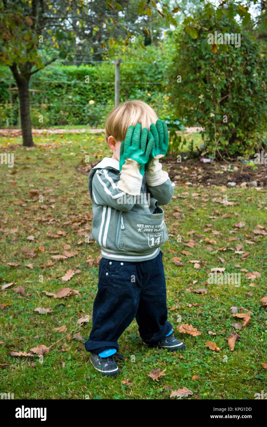 Trois ans se cache derrière des profils des gants de jardinage dans un jeu  de cache-cache dans un jardin Photo Stock - Alamy