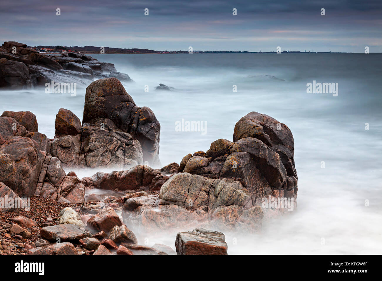 Une longue exposition de coucher du soleil à plage de rochers. Kullaberg, Suède. Banque D'Images