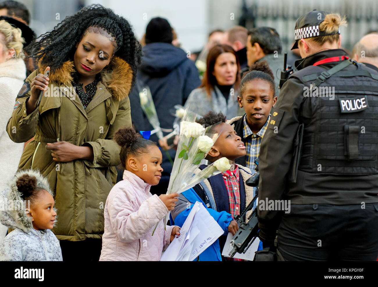 Londres, Royaume-Uni. La famille noire à parler à une femme officier de police armés à l'extérieur de la Cathédrale St Paul après un service commémoratif (14 décembre 2017) pour Grenfell... Banque D'Images