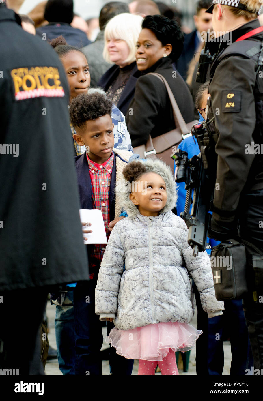 Londres, Royaume-Uni. La famille noire à parler à une femme officier de police armés à l'extérieur de la Cathédrale St Paul après un service commémoratif (14 décembre 2017) pour Grenfell... Banque D'Images