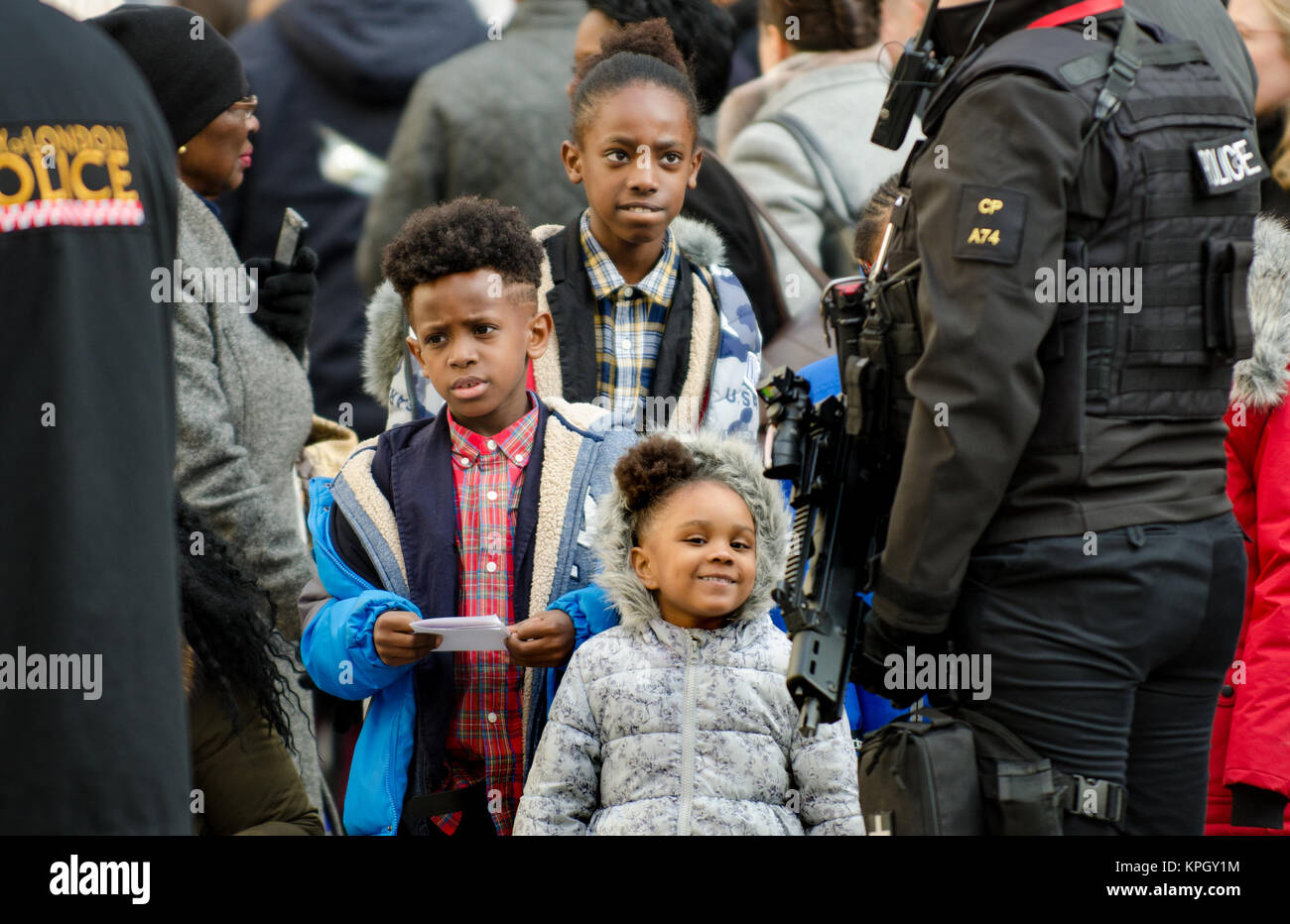 Londres, Royaume-Uni. La famille noire à parler à une femme officier de police armés à l'extérieur de la Cathédrale St Paul après un service commémoratif (14 décembre 2017) pour Grenfell... Banque D'Images