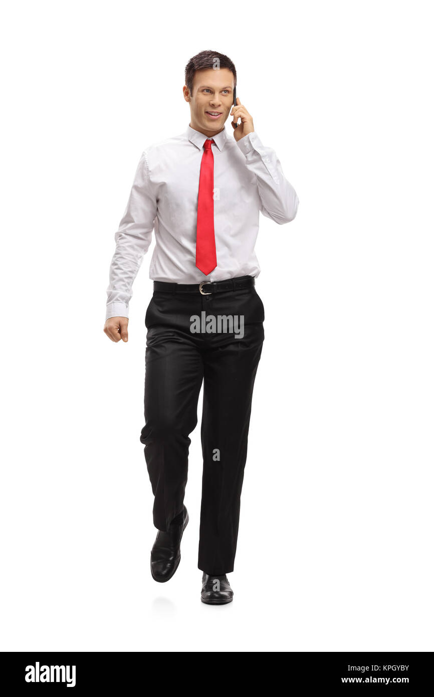 Portrait d'un homme élégant marchant et parlant sur un téléphone isolé sur fond blanc Banque D'Images