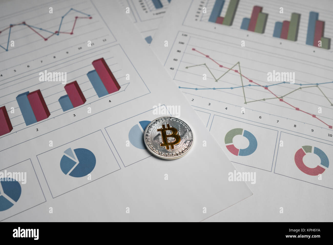 Pièce en argent avec un symbole d'or bitcoin sur le contexte de l'investissement des graphiques Banque D'Images