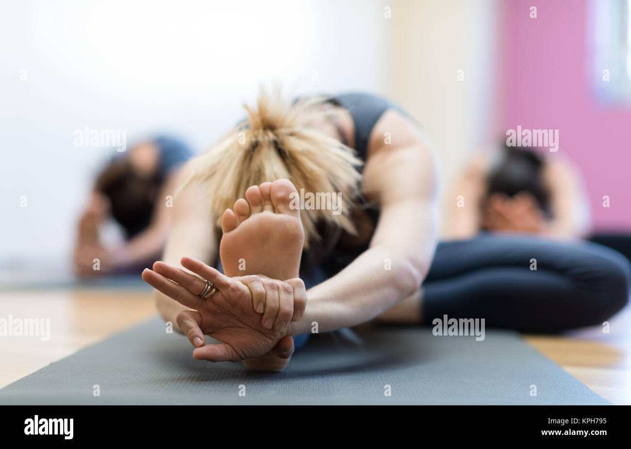 Femme faisant de l'exercice physique et l'étirement des jambes sur un tapis de pied, Close up, concept de vie sain Banque D'Images