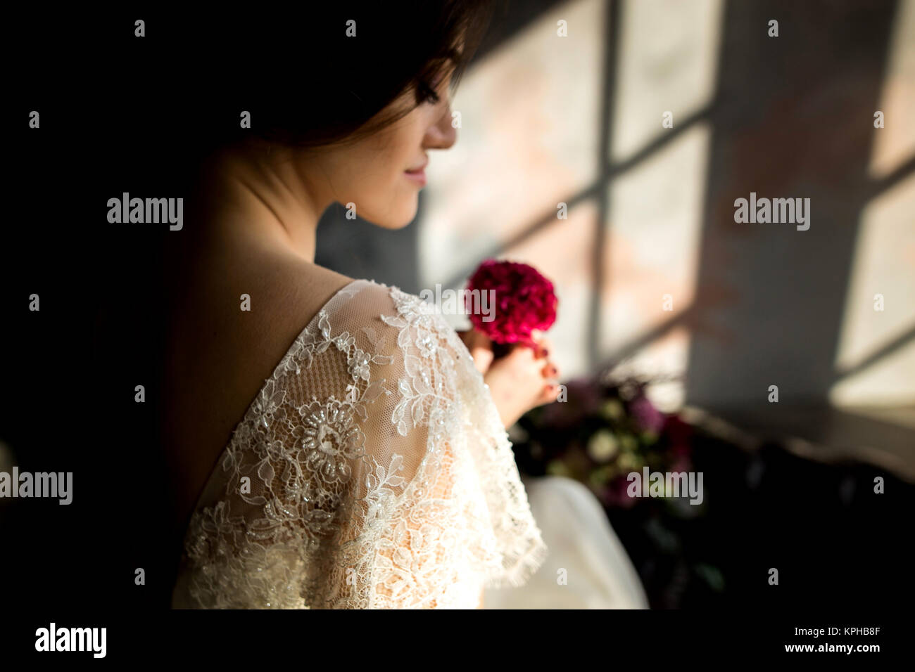 Belle robe de mariée assis sur une chaise à l'intérieur dans dark studio intérieur comme à la maison. Banque D'Images