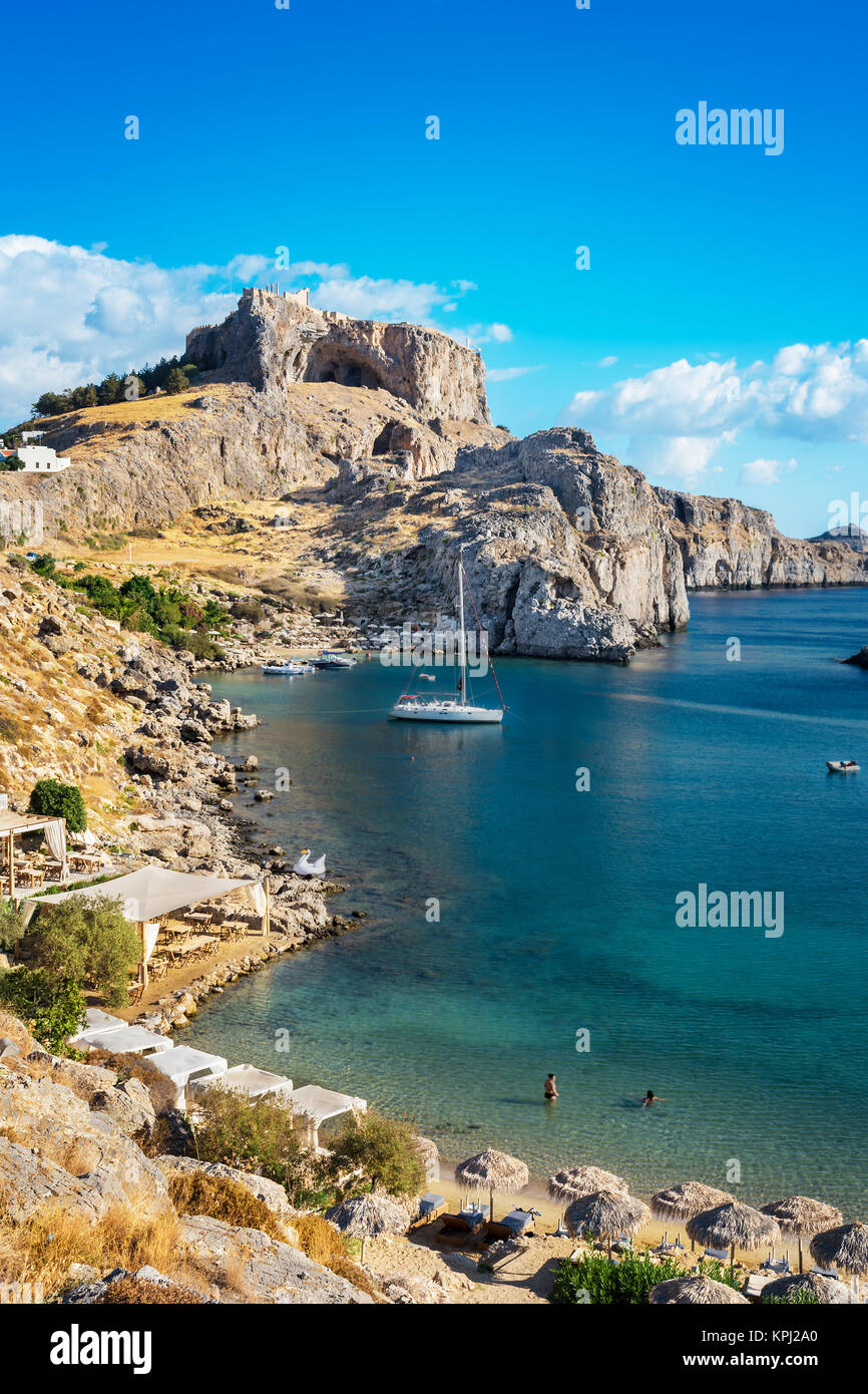 Belle la baie de Saint Paul avec des bateaux, de l'Acropole de Lindos en arrière-plan (Rhodes, Grèce) Banque D'Images