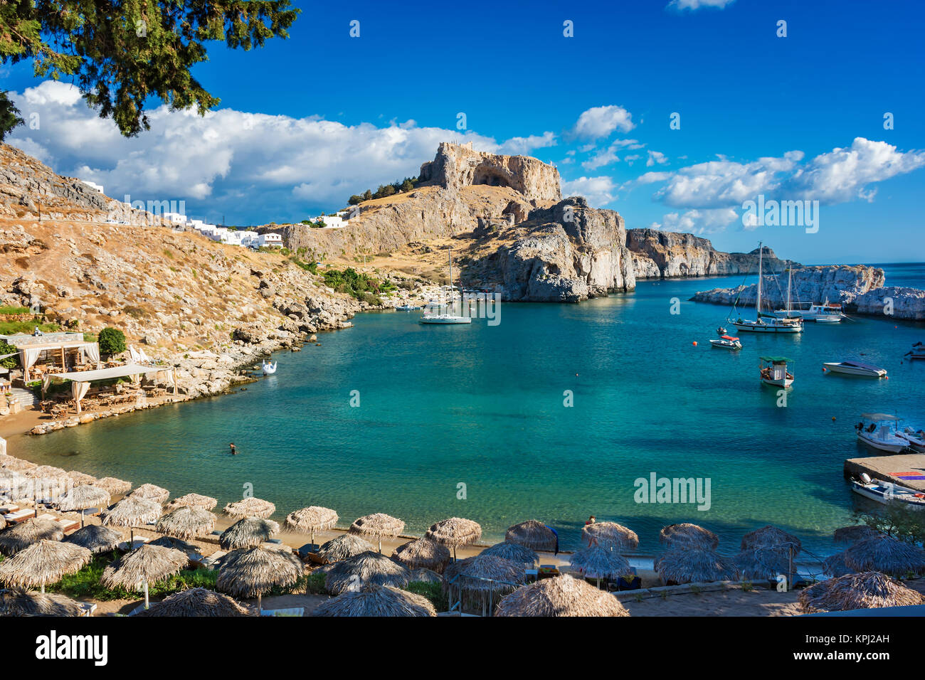 Belle la baie de Saint Paul avec des bateaux, de l'Acropole de Lindos en arrière-plan (Rhodes, Grèce) Banque D'Images