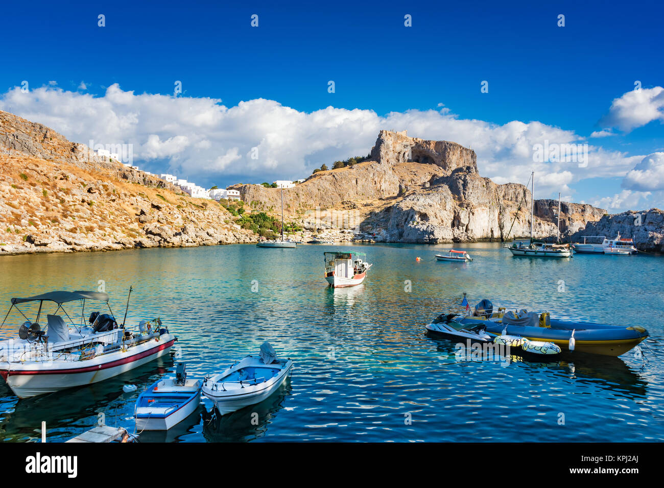 Des bateaux de pêche, zodiac, jet ski dans la baie de Saint Paul, l'Acropole de Lindos en arrière-plan (Rhodes, Grèce) Banque D'Images