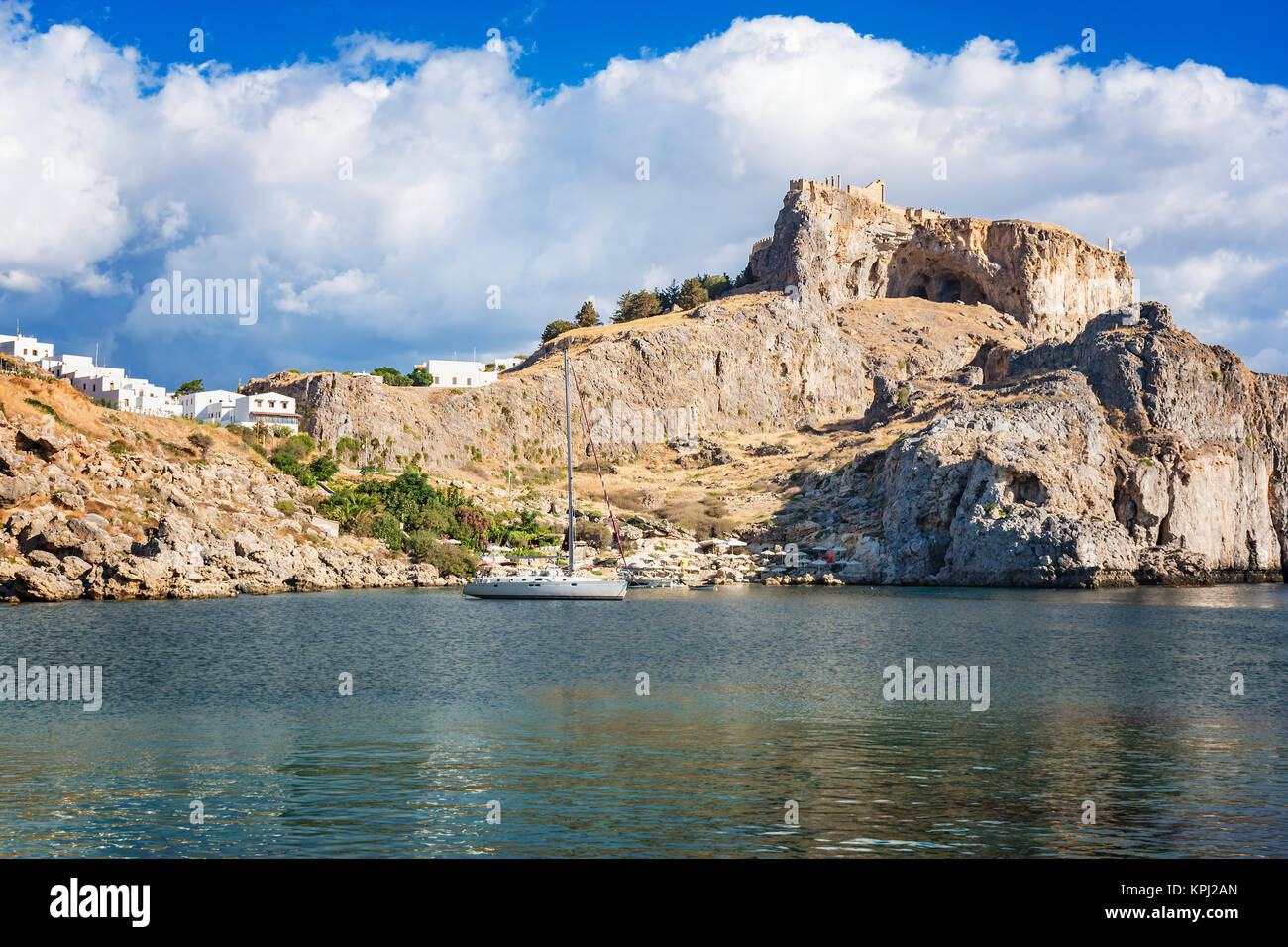La voile dans la baie de Saint Paul, ciel nuageux ciel bleu, Lindos acropole en arrière-plan (Rhodes, Grèce) Banque D'Images