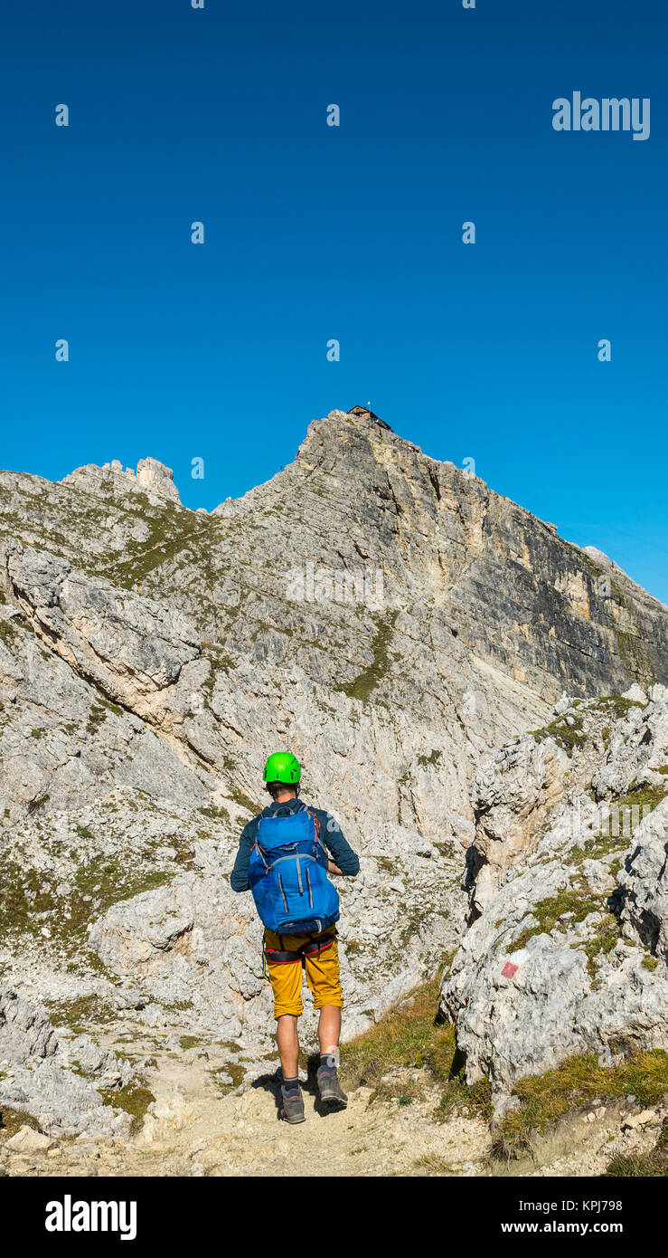 Randonneur avec casque d'escalade sur sentier à Nuvolau, vue sur le sommet avec Nuvolau Rifugio Nuvolau, Dolomites, le Tyrol du Sud Banque D'Images