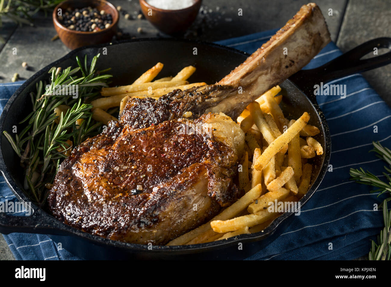 Les steaks cuits Tomahawk nourri à l'herbe avec des frites et de romarin Banque D'Images