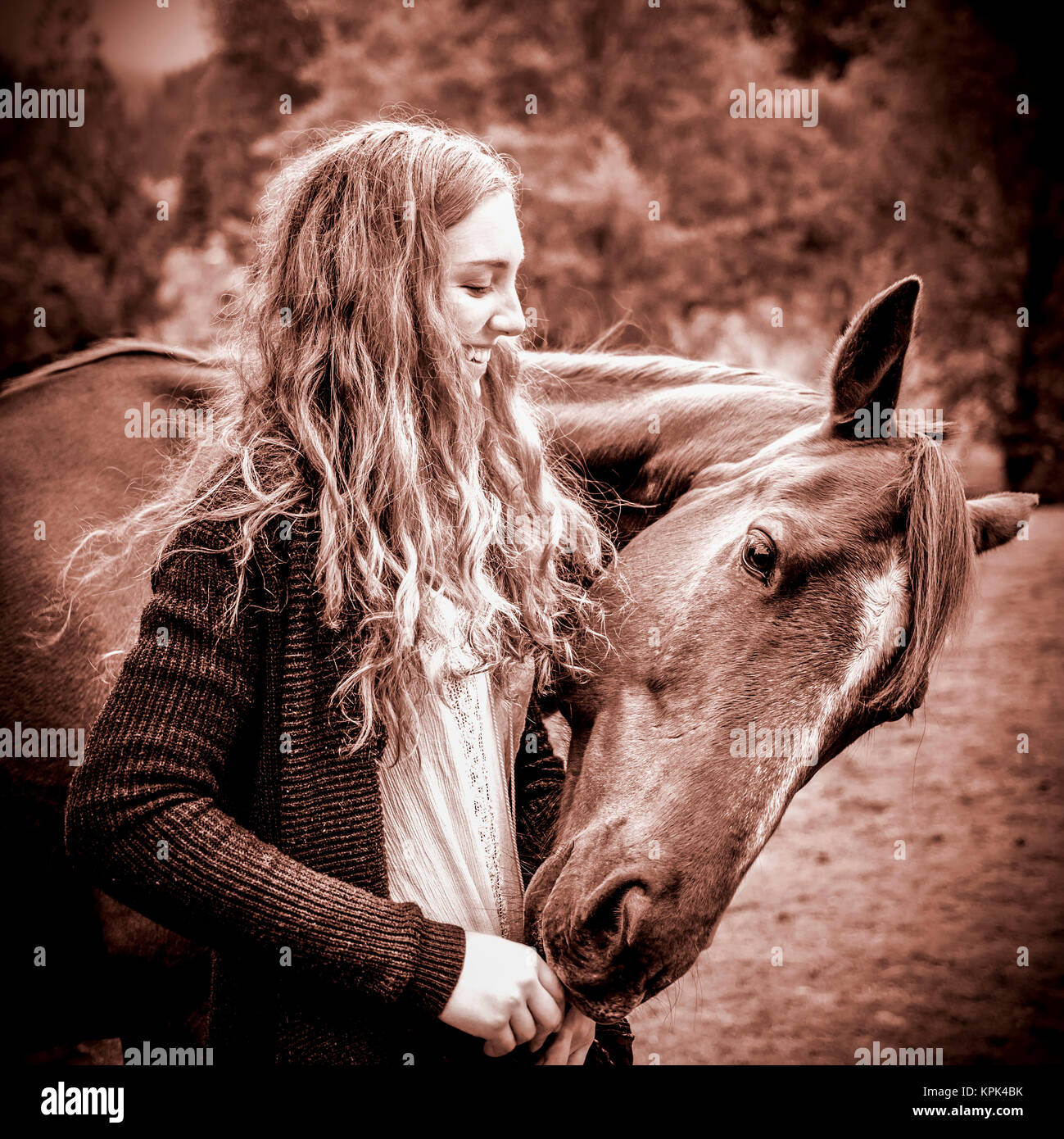 Une adolescente et son cheval broutant sur ses mains ; British Columbia, Canada Banque D'Images