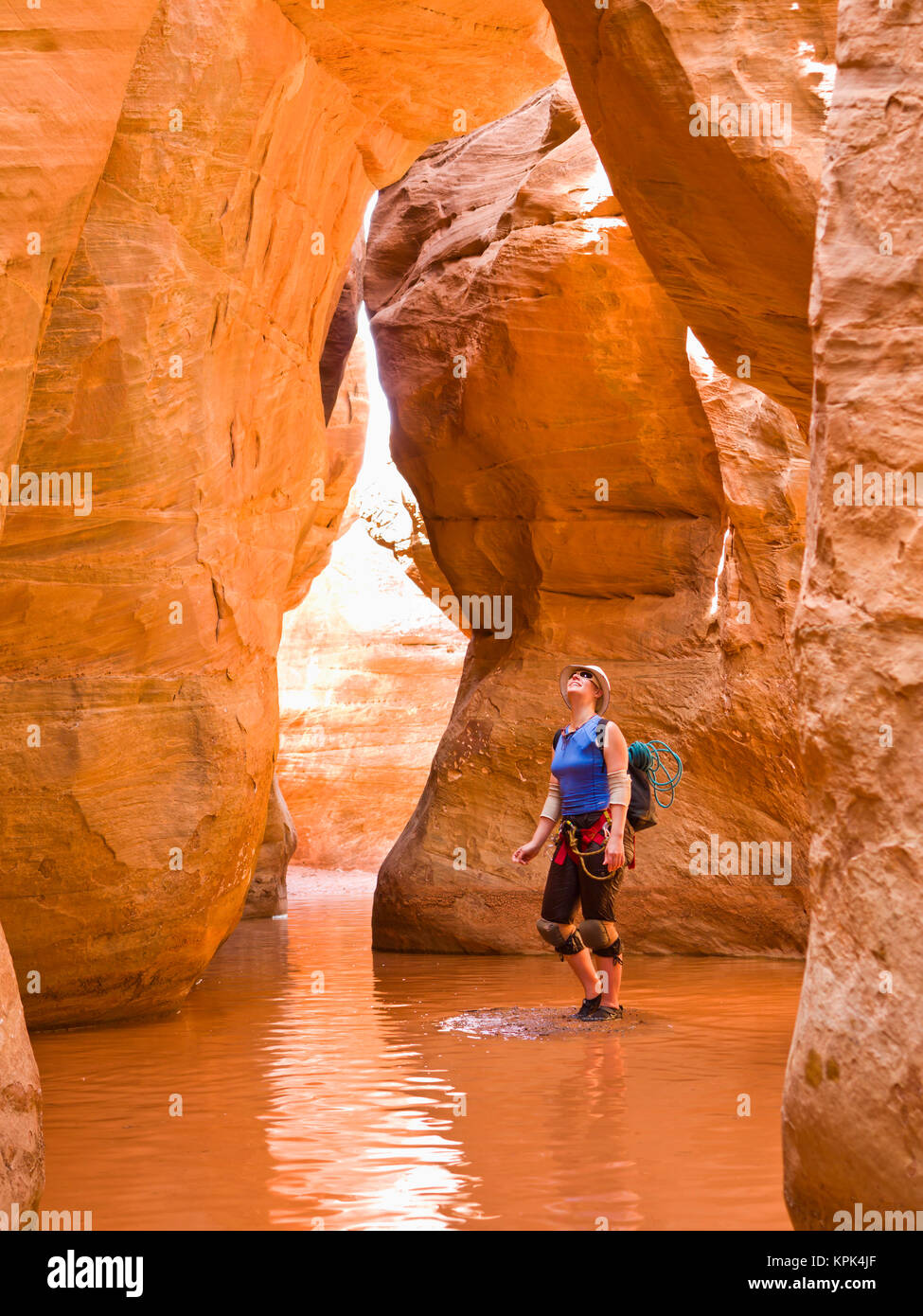 Un aventurier femme admirant la hauteur de la fente canyon elle est entourée d'eau ; à Hanksville, Utah, États-Unis d'Amérique Banque D'Images