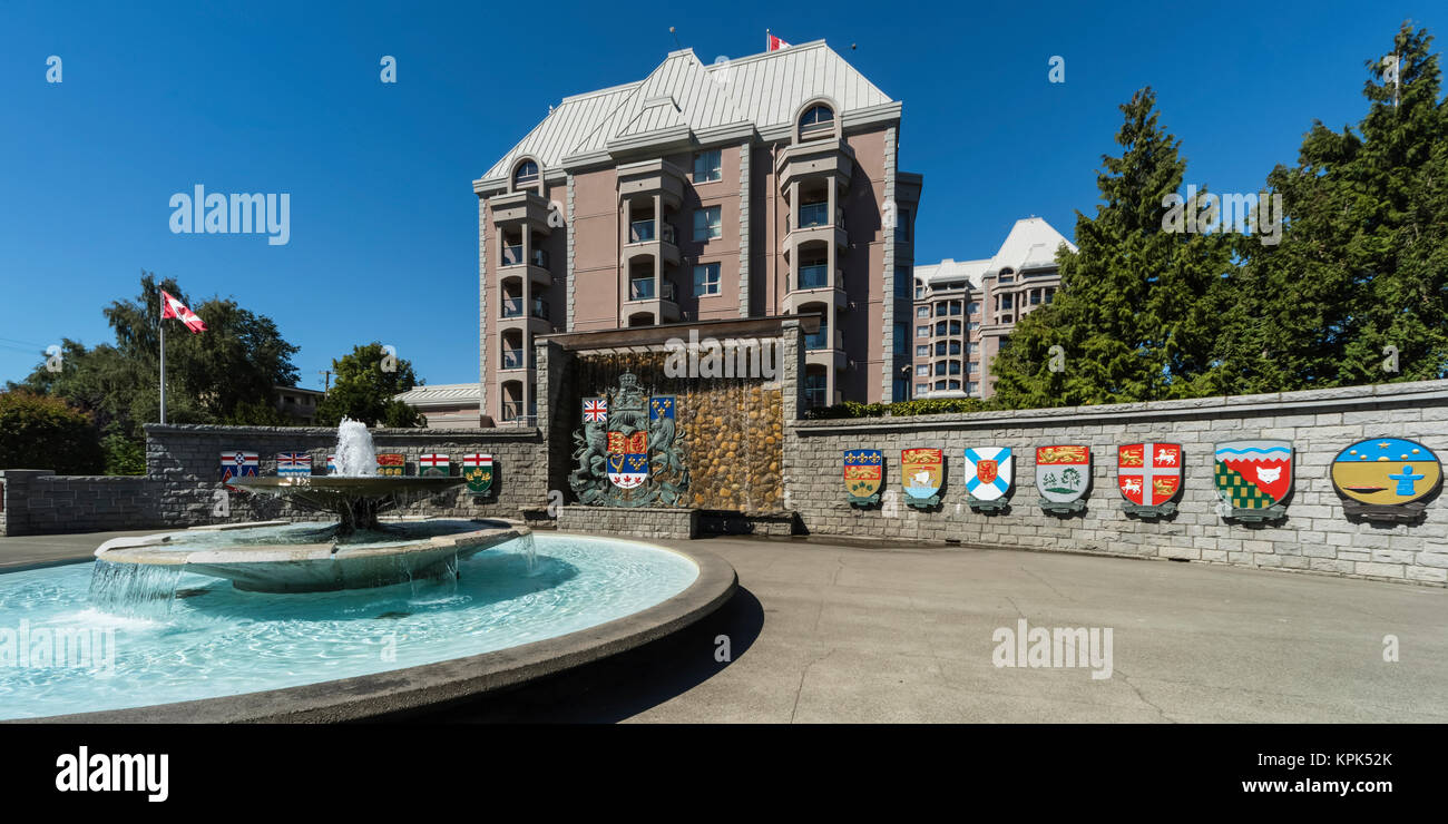 Les crêtes colorées symbolique sur un mur de pierre et fontaine à eau le long d'une allée piétonnière Victoria, British Columbia, Canada Banque D'Images