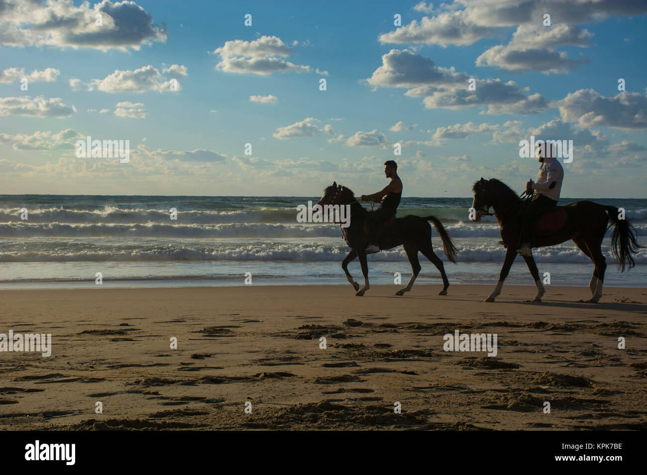 Deux hommes cheval d'équitation sur la plage Banque D'Images