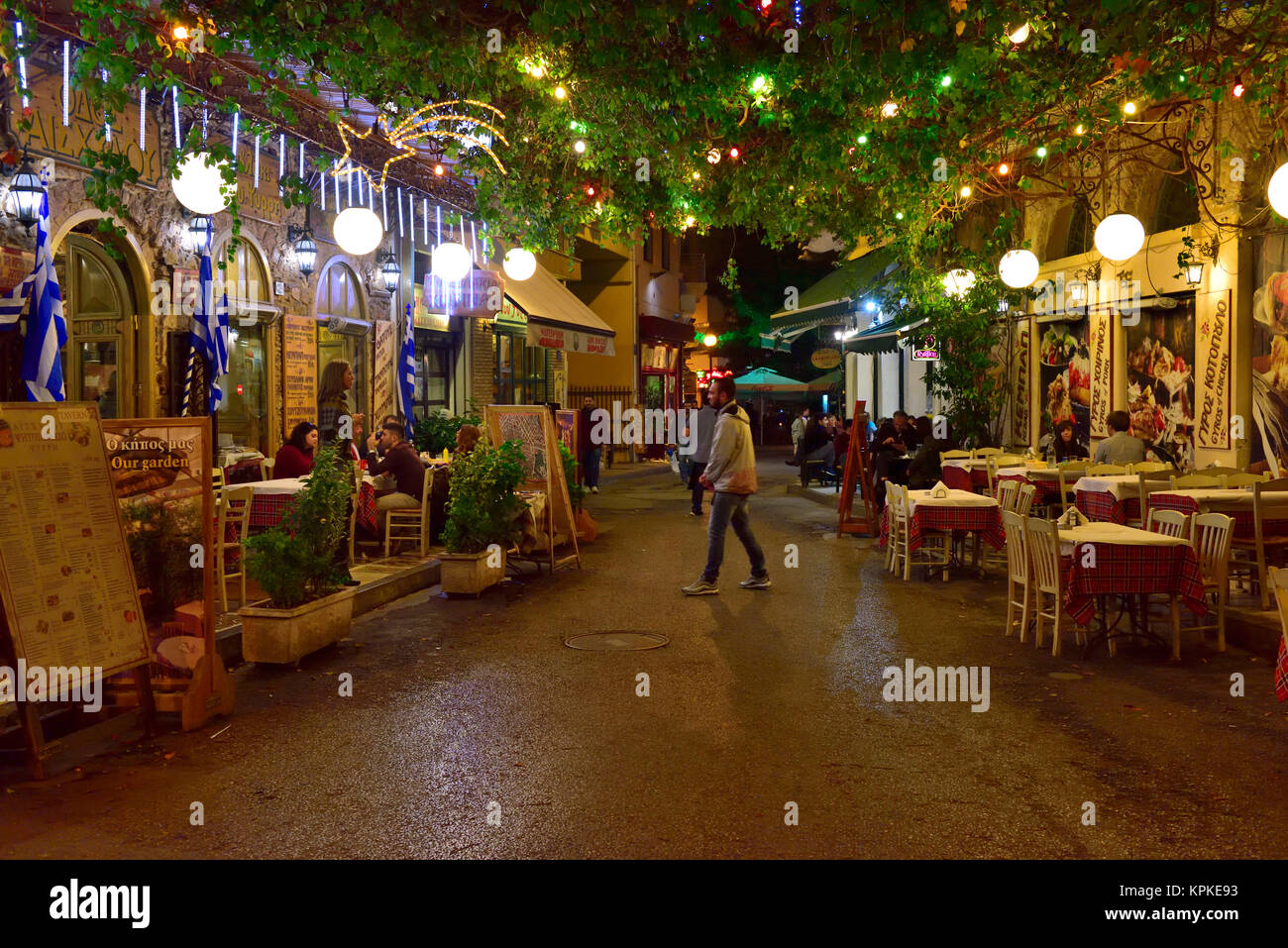 Scène de rue la nuit dans le centre d'Athènes dans la petite ruelle entre deux restaurants Banque D'Images
