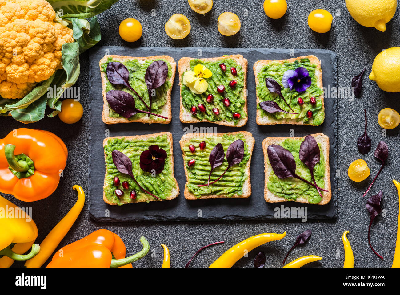 Le petit-déjeuner sandwich avocat différents. Différentes couleurs fraîches légumes biologiques. vegan aliments crus sains sur fond gris. Banque D'Images