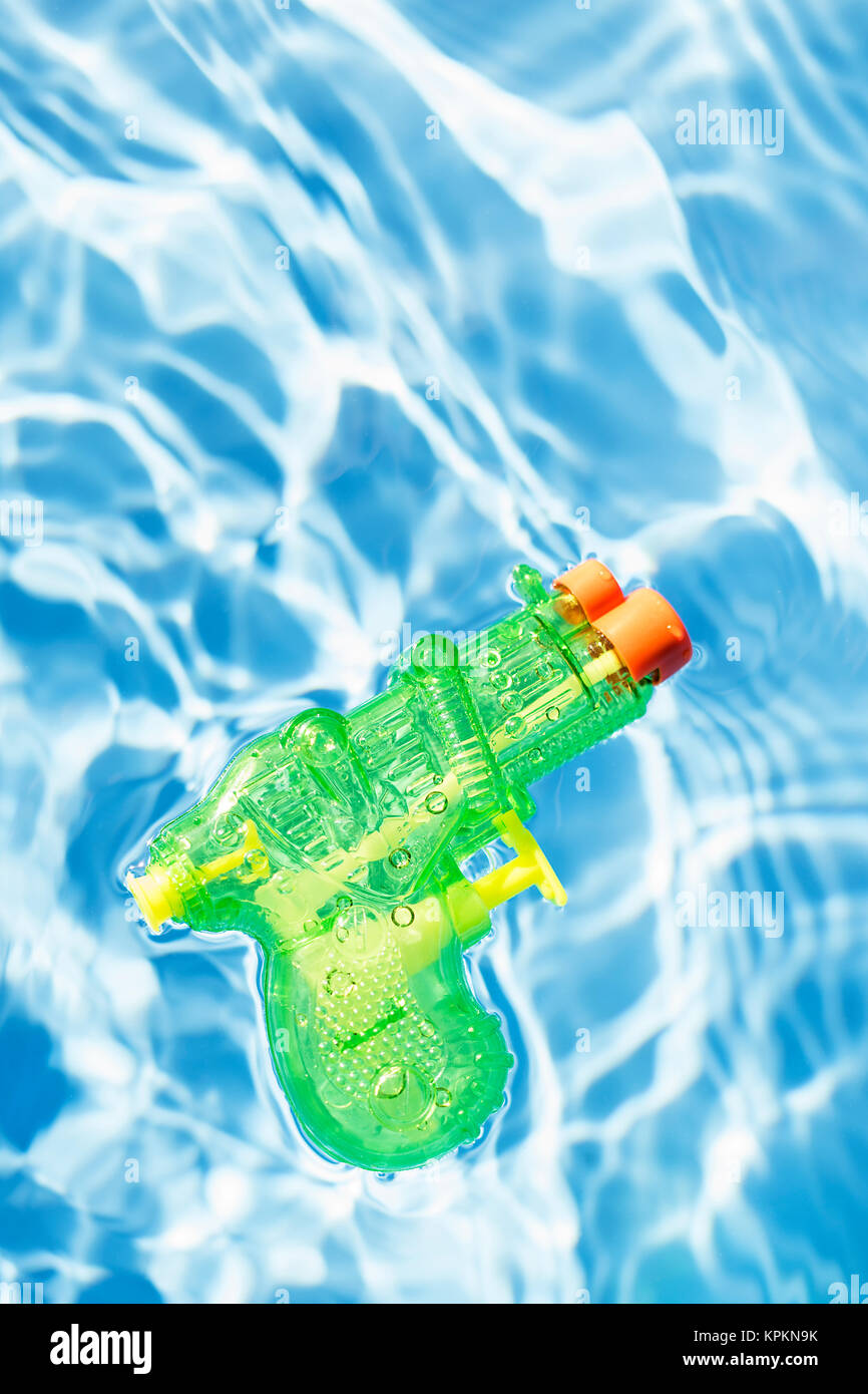 Squirt gun verte flottant dans une piscine. Banque D'Images