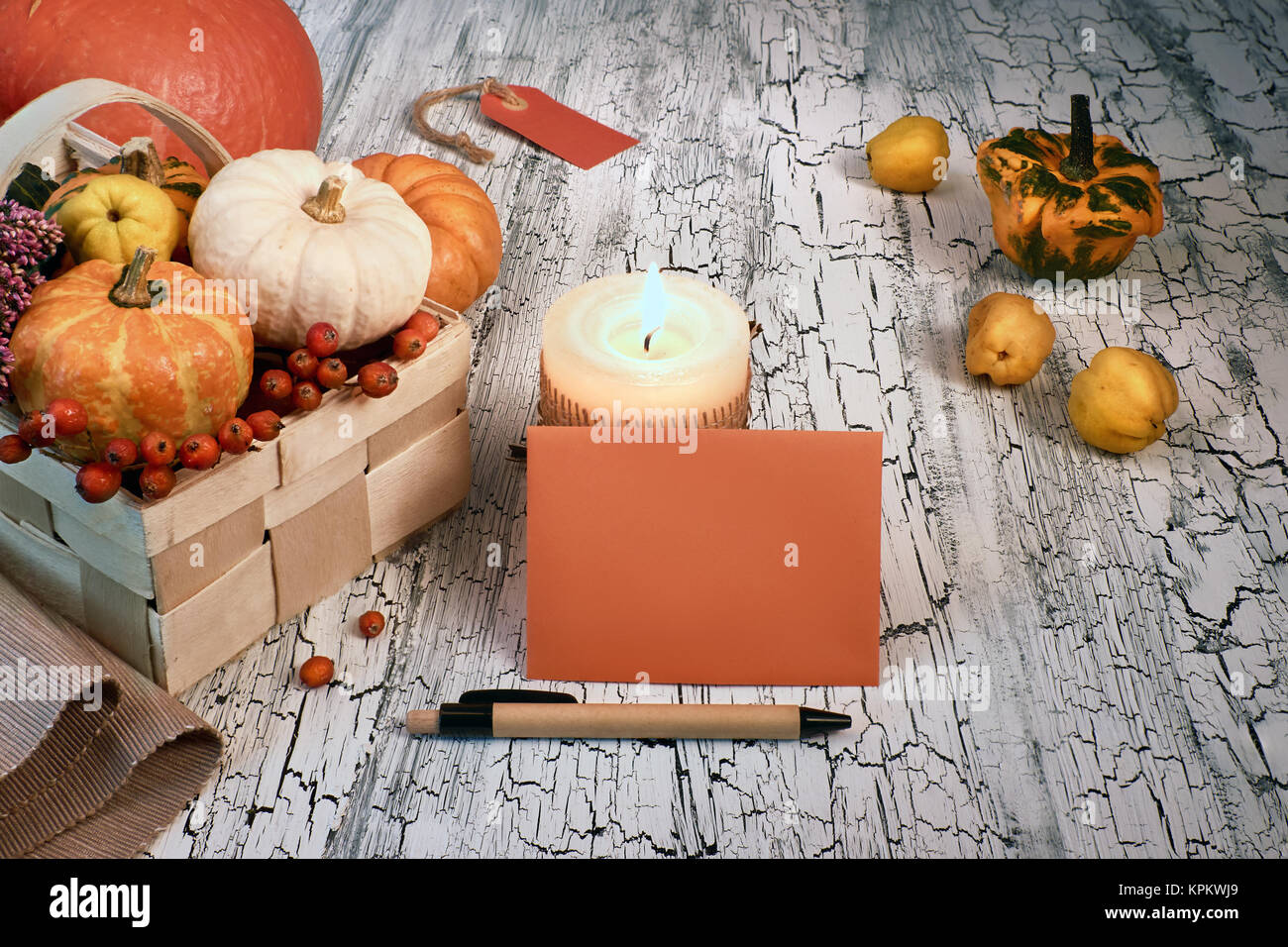 Arrangement d'automne avec les citrouilles, les bougies et l'enveloppe vide sur une table rustique. L'espace texte, immersive, tonique libre Banque D'Images