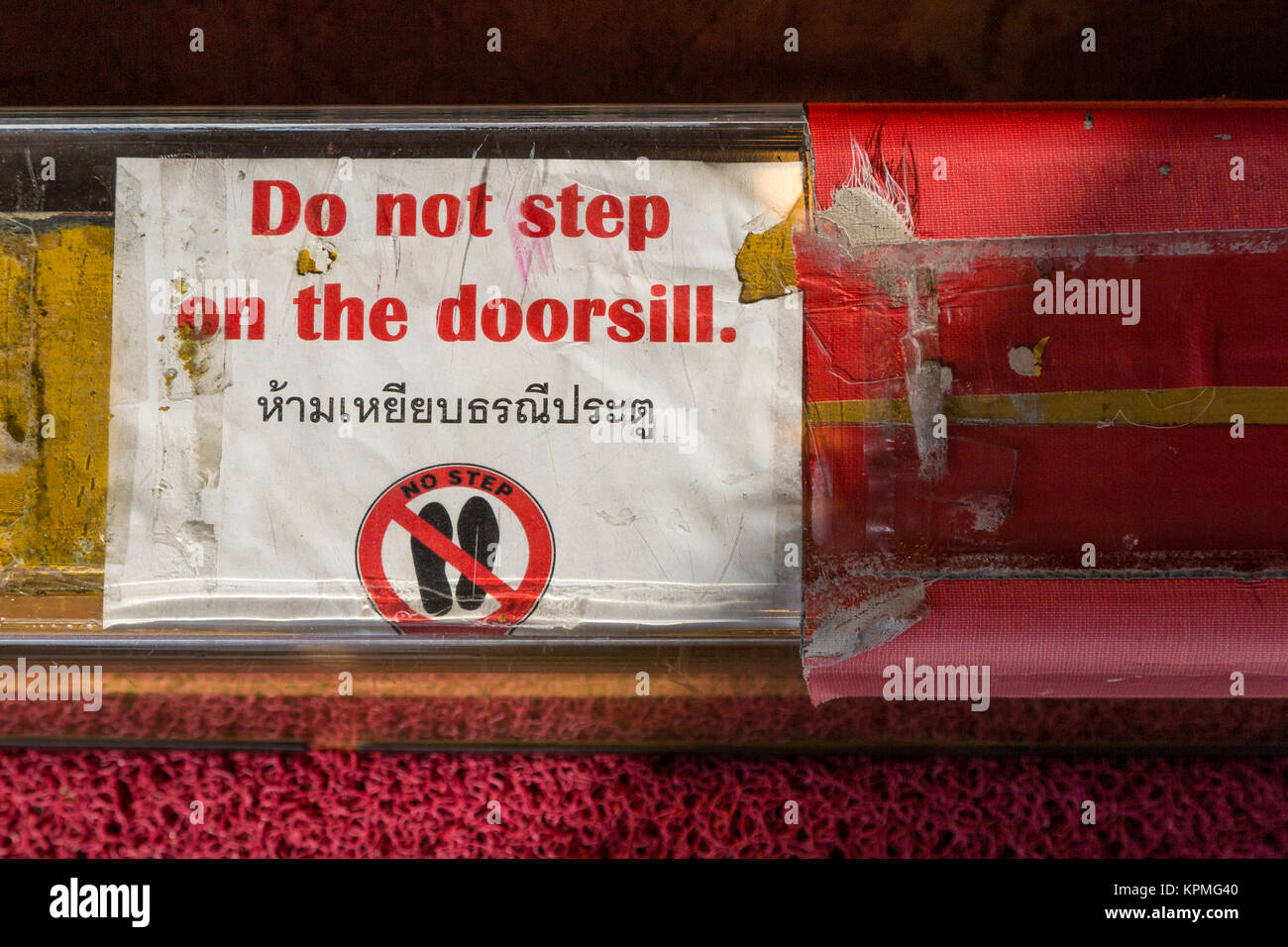 Bangkok, Thaïlande. Wat Traimit, le Temple du Bouddha d'or. Inscrivez-vous à des étrangers d'alerte personnalisée : un Thaïlandais ne fait pas un pas sur le seuil d'une porte. Banque D'Images