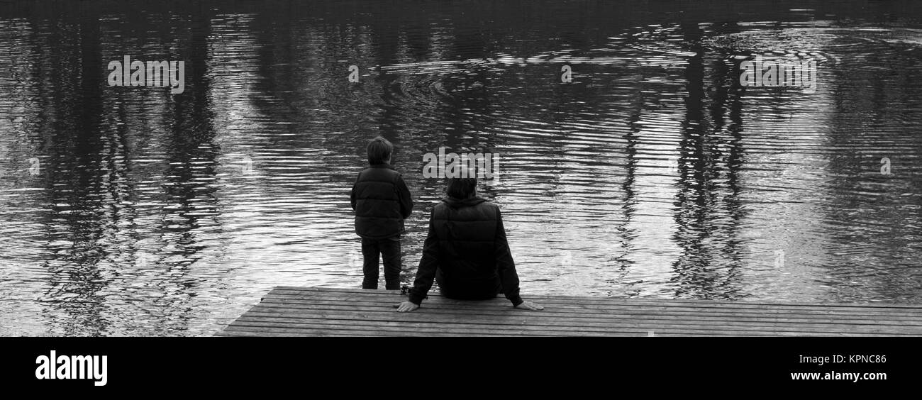 père et fils regardent un lac Banque D'Images