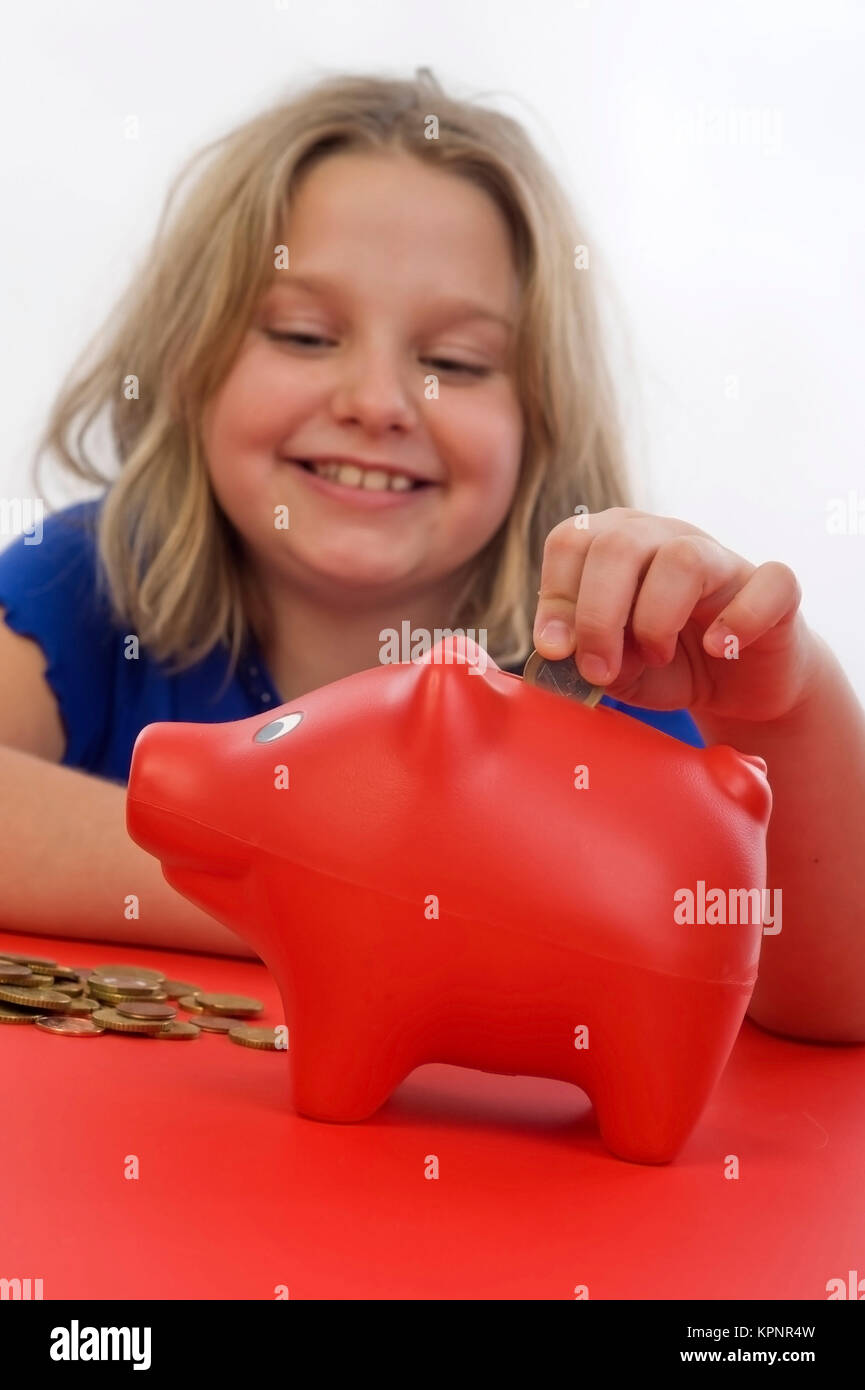 Modèle libération , Maedchen, 8 Jahre, fuettert Sparschwein - Girl with piggy bank Banque D'Images