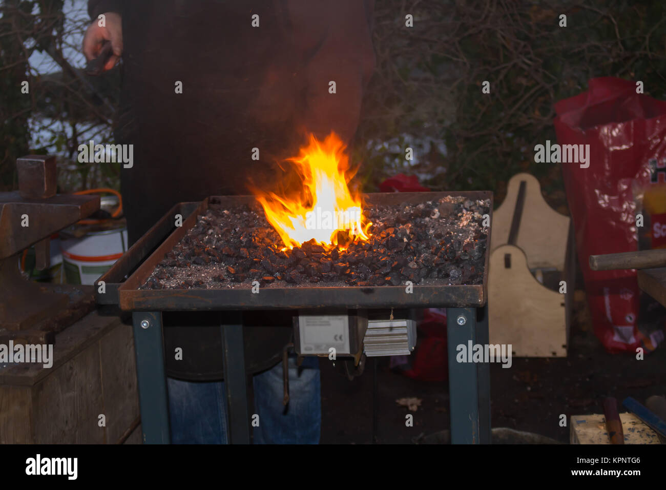 Le forgeron forge manuellement le métal en fusion sur l'enclume dans la forge d'artifice d'étincelles Banque D'Images