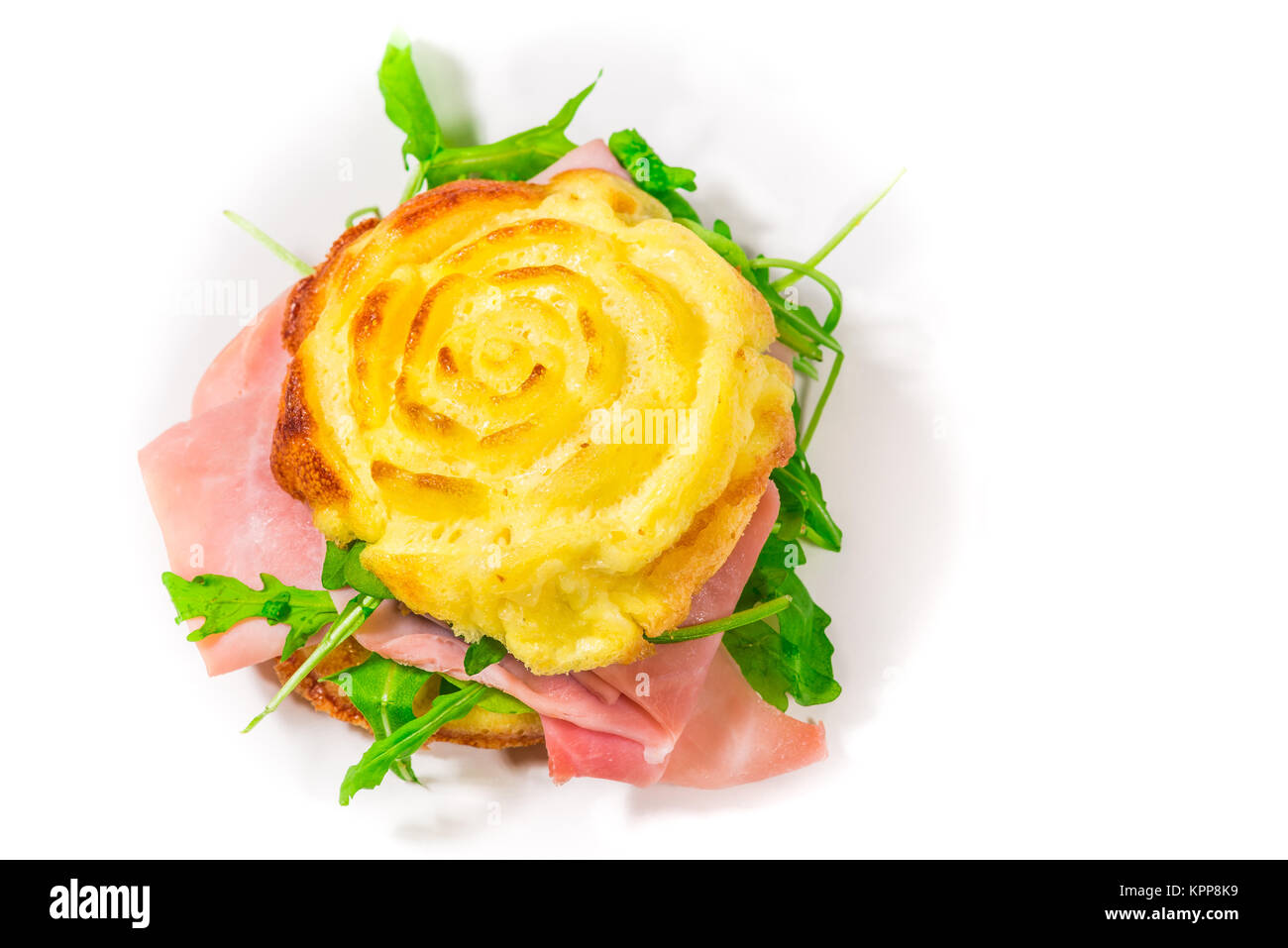 Frittata farci, cuit dans le four à micro-ondes, en forme de rose, avec salade de roquette et jambon cuit (ingrédients : oeufs, la crème, le sel, l'emmental) Banque D'Images