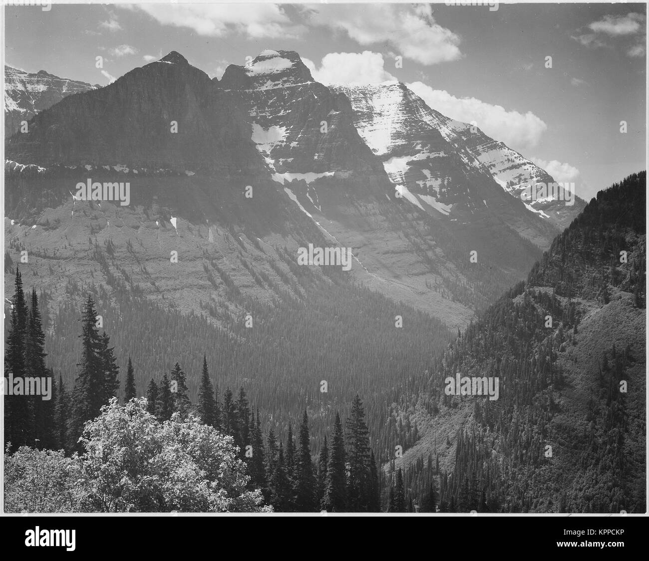 Montagnes couvertes de neige de la vallée en arrière-plan "dans le Glacier National Park du Montana". 1933 - 1942 Banque D'Images
