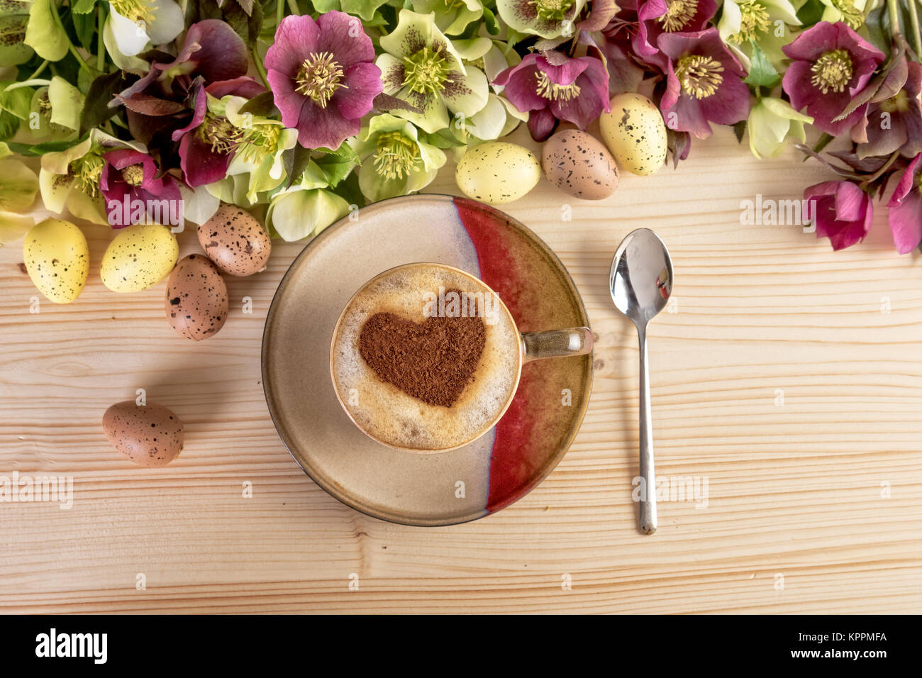 Café avec forme de coeur et fleurs Décoration de Pâques sur la table en bois. Vue d'en haut Banque D'Images