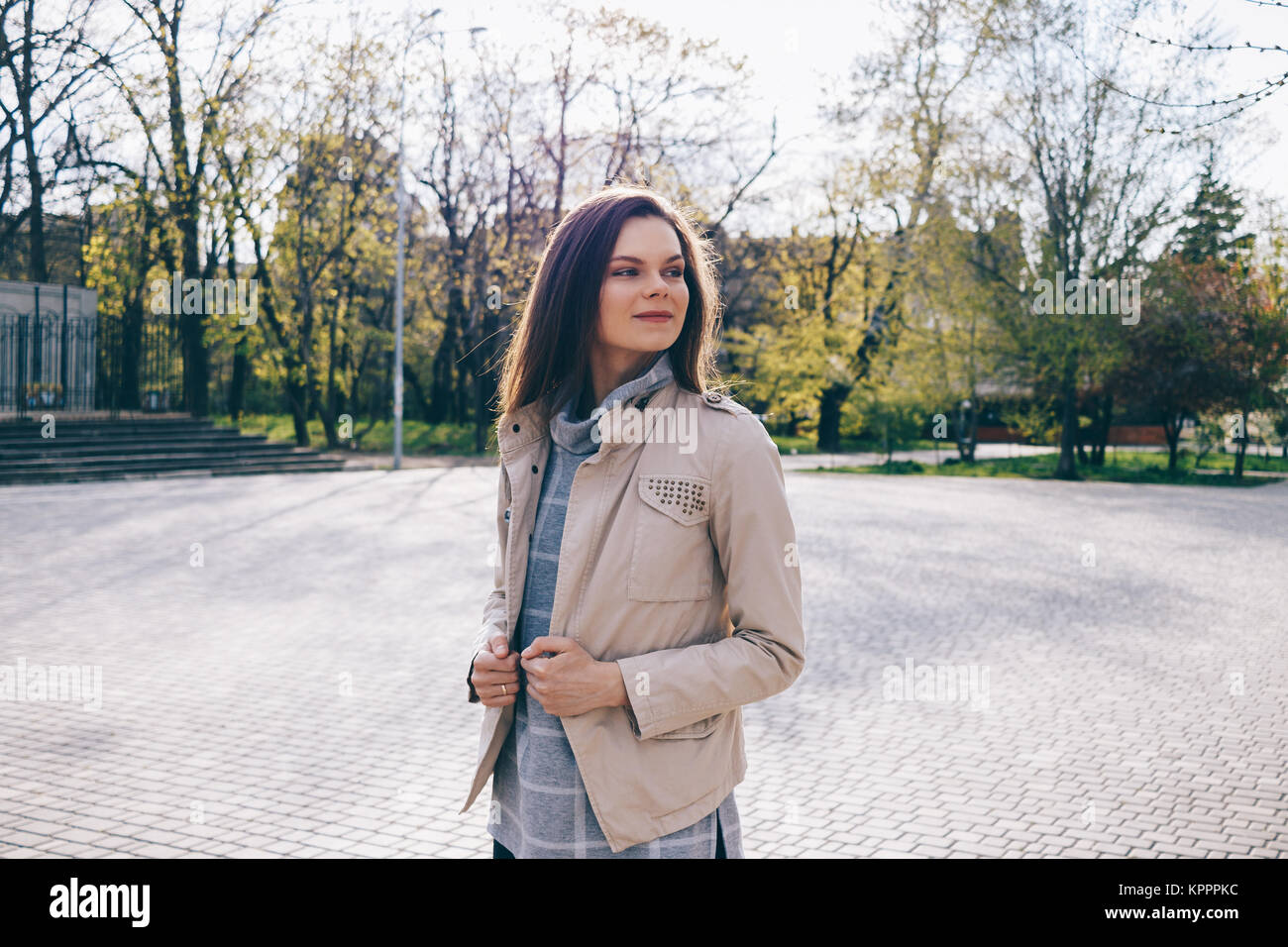 Femme svelte dans une veste beige promenades à travers le parc en automne Banque D'Images