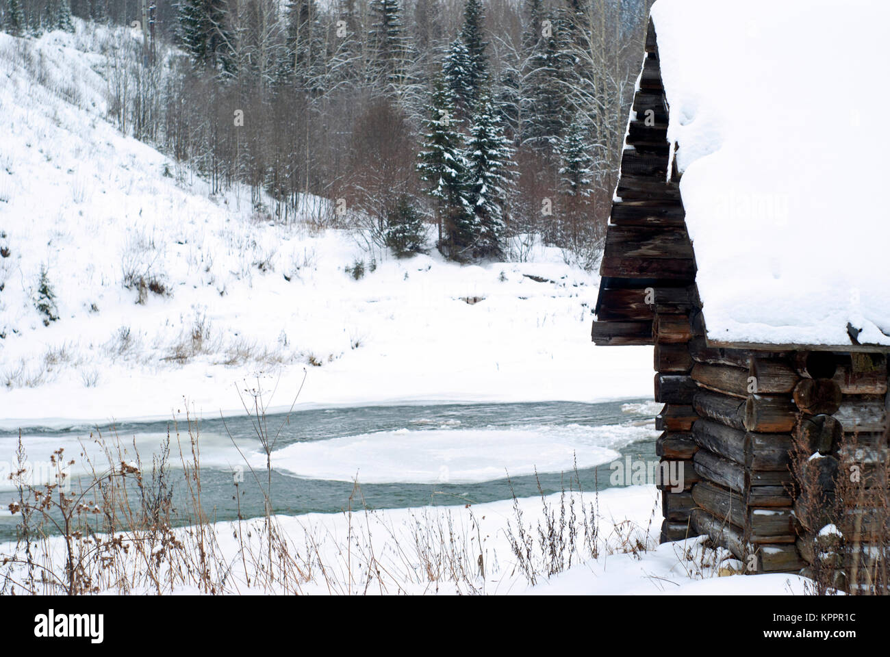 Fragment d'un ancien journal cabane de chasse sur la rive du fleuve dans un paysage d'hiver Banque D'Images