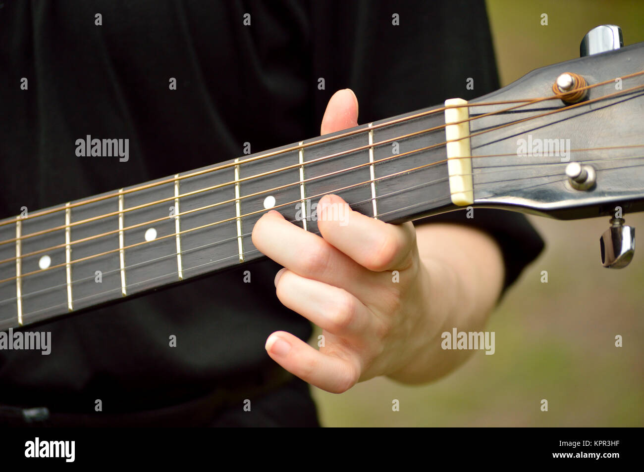 Gros plan du manche de guitare avec le guitariste jouant Banque D'Images