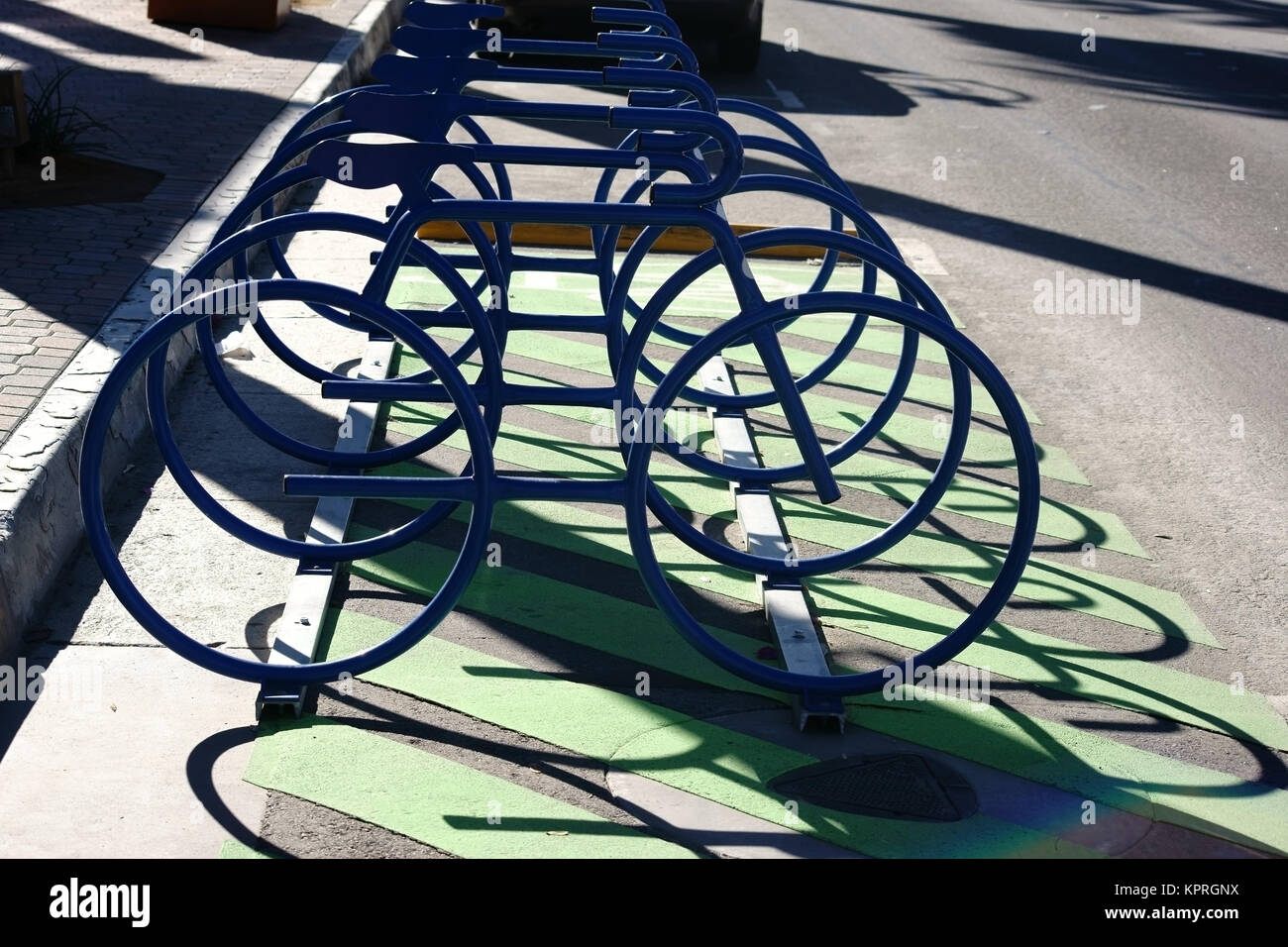 Abstrakte dans Reihe angeordnete Fahrradständer werfen einen Schatten und haben die Form von Rennrades. Banque D'Images