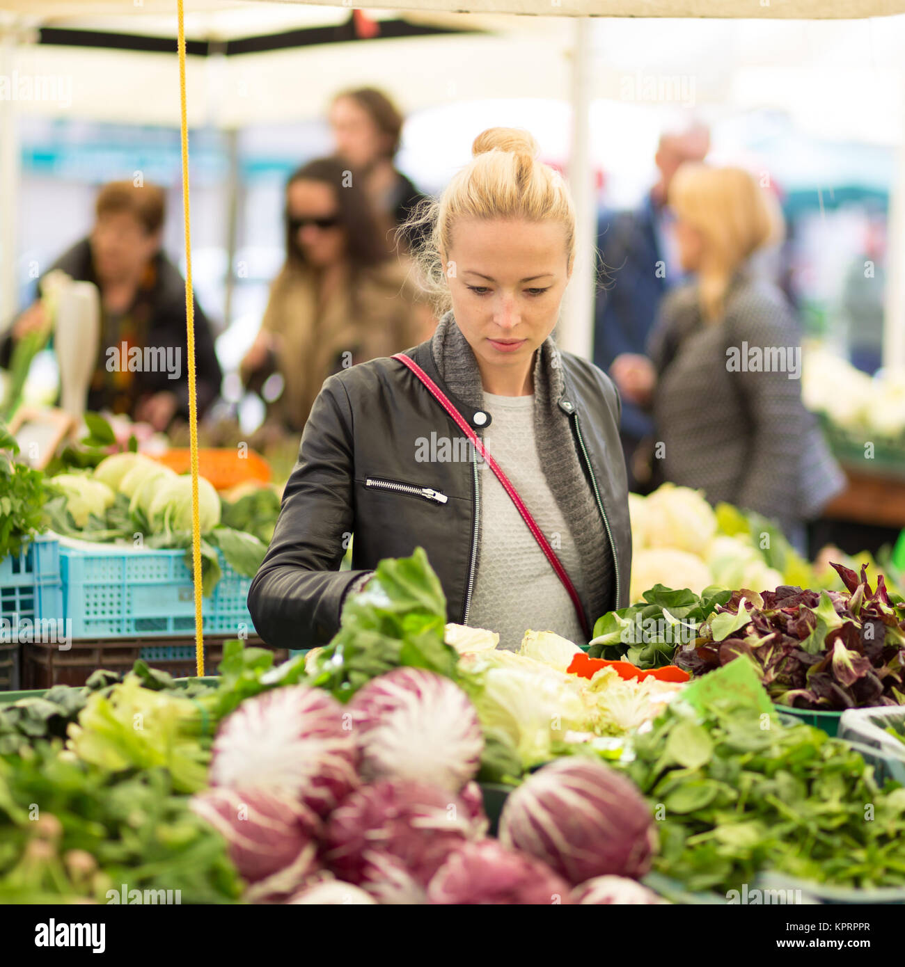 Femme l'achat d'aliments locaux de légumes au marché. Banque D'Images