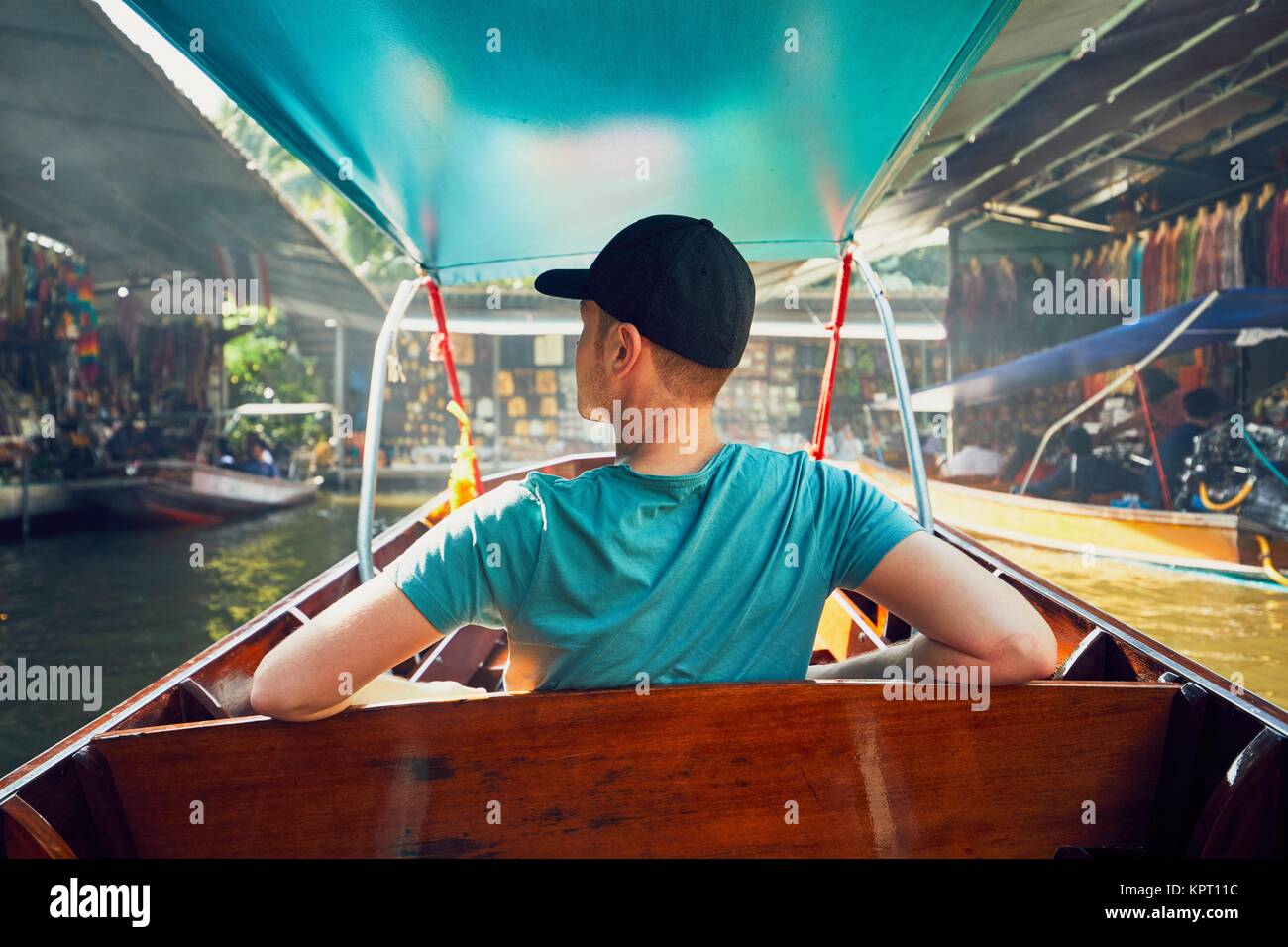 Jeune homme (meilleur) sur le bateau. Marché flottant de Damnoen Saduak traditionnels à Ratchaburi près de Bangkok, en Thaïlande. Banque D'Images