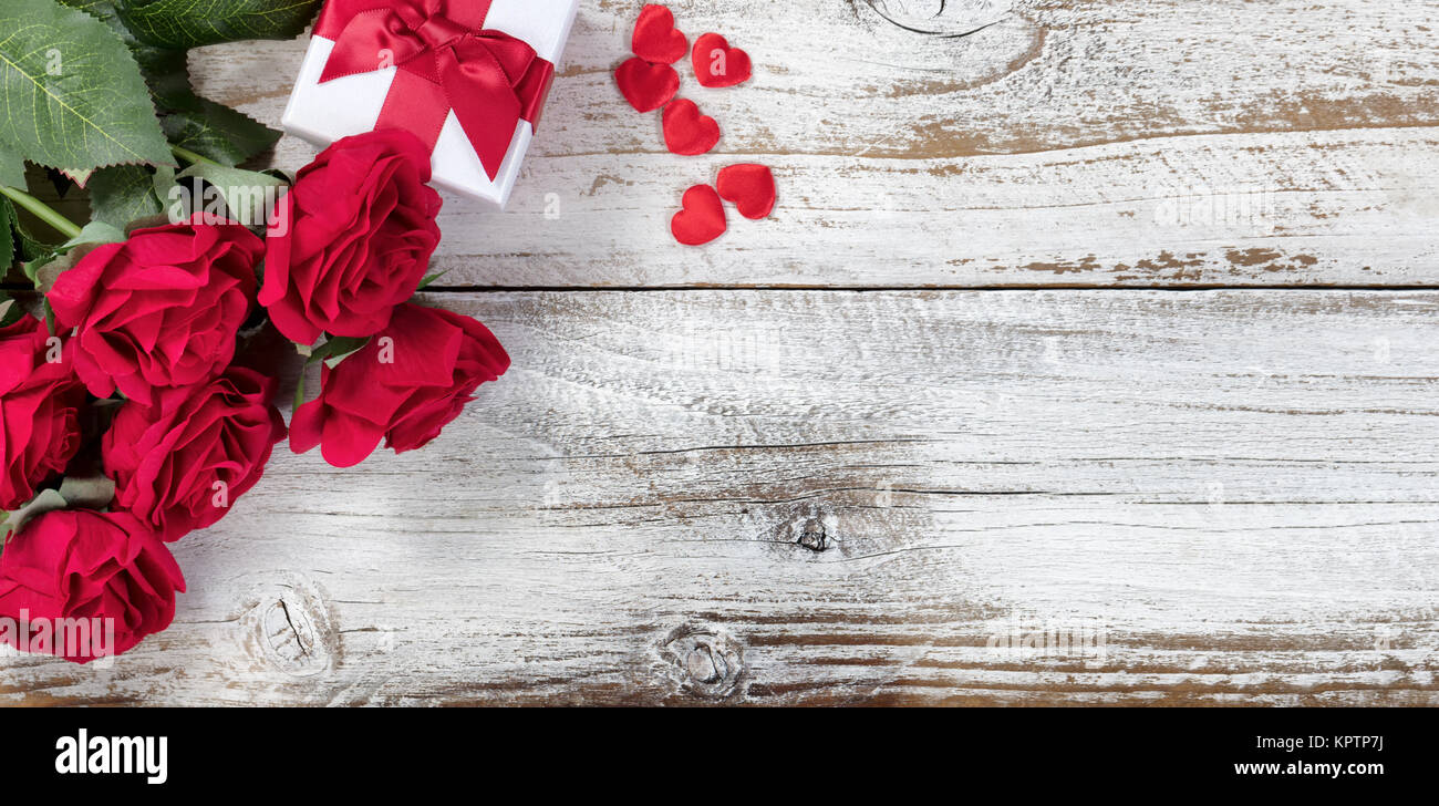 Boîte-cadeau avec des roses rouges et coeurs en bois rustique en vue mise à plat Banque D'Images