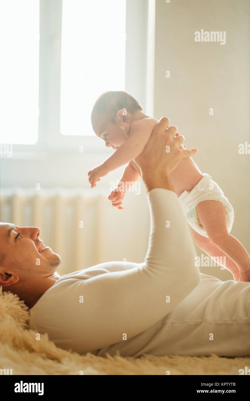 Père couché avec mignon bébé fille on bed Banque D'Images