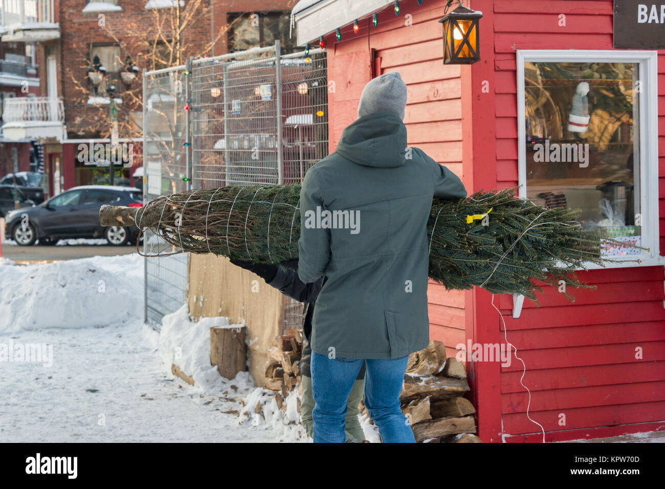 Montréal, Canada - 16 décembre 2017 : un homme porte un arbre de Noël Banque D'Images