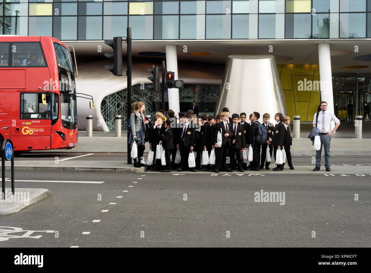 Groupe d'enfants en uniforme de l'école avec leur enseignant d'attente à un passage pour piétons à Londres Angleterre Octobre 2017 Banque D'Images