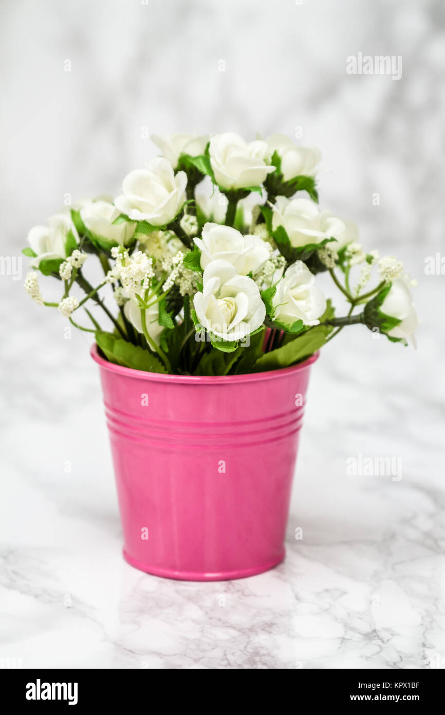 Les petites fleurs blanches artificielles décoratives en Pot Rose Photo  Stock - Alamy