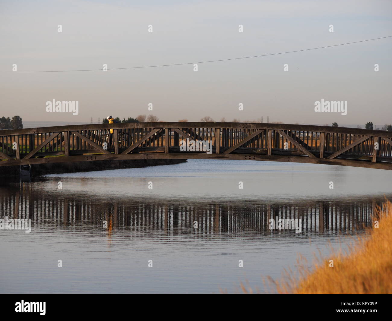 Sheerness, Kent, UK. Dec 18, 2017. Météo France : un matin ensoleillé (temp 4c à 9h00). Un cycliste traverse le pont sur le canal des lignes défensives de Sheerness. Credit : James Bell/Alamy Live News Banque D'Images