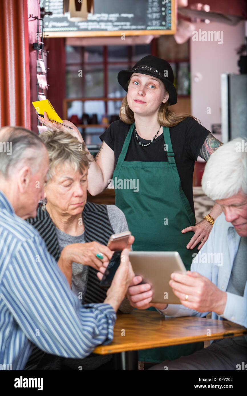 Les clients en attente sur le serveur frustré avec électronique Banque D'Images