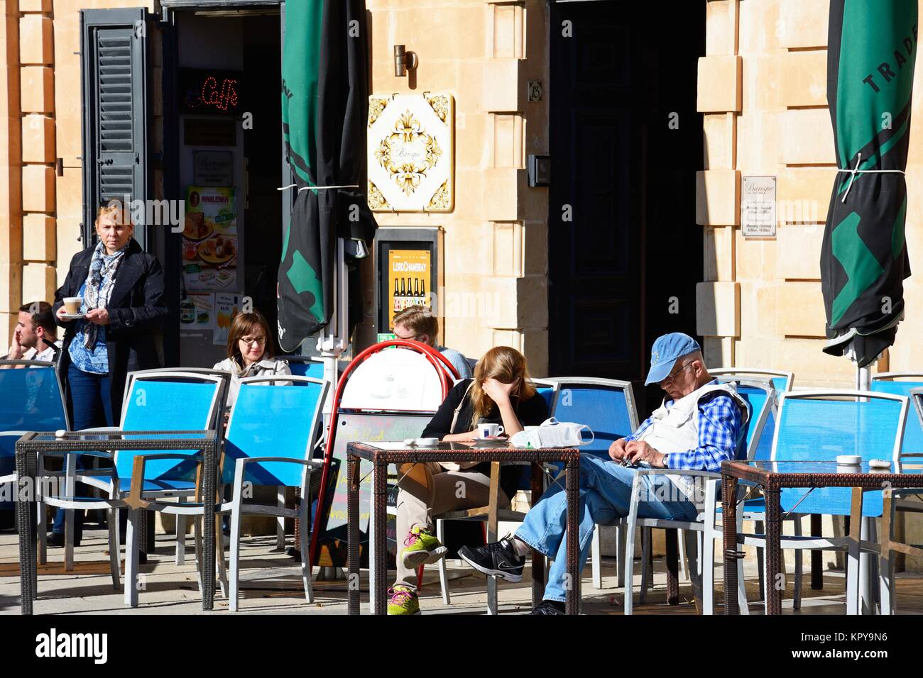 Les touristes se détendre à la terrasse d'un café dans le centre-ville, Mosta, de Malte, de l'Europe. Banque D'Images