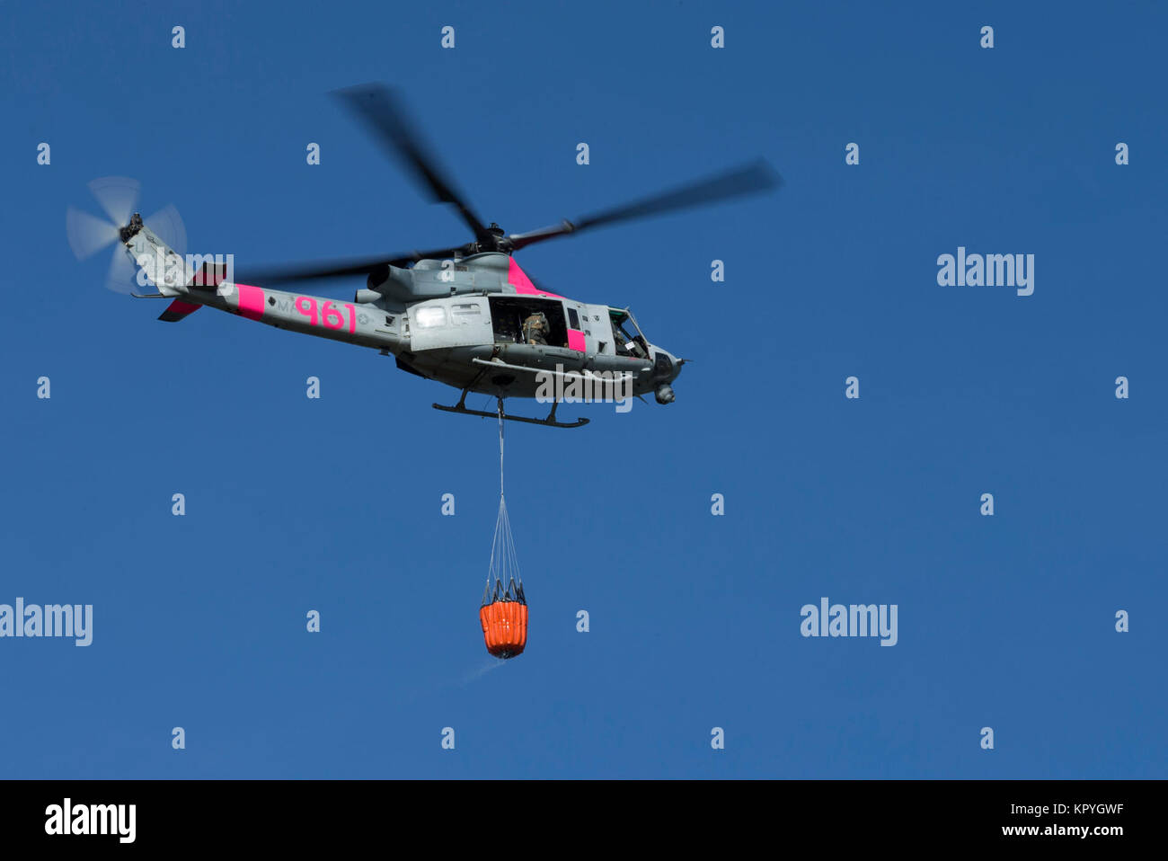 Un UH-1Y venin d'hélicoptère léger, l'escadron maritime prend son envol avec un plein seau d'eau du lac O'Neal à bord de Camp Pendleton, en Californie, le 8 décembre 2017. Marine Corps Air Station, Camp Pendleton, UH-1Y 3ème oeil peut transporter jusqu'à 320 litres d'eau pour aider à contenir l'incendie de lilas. (U.S. Marine Corps Banque D'Images