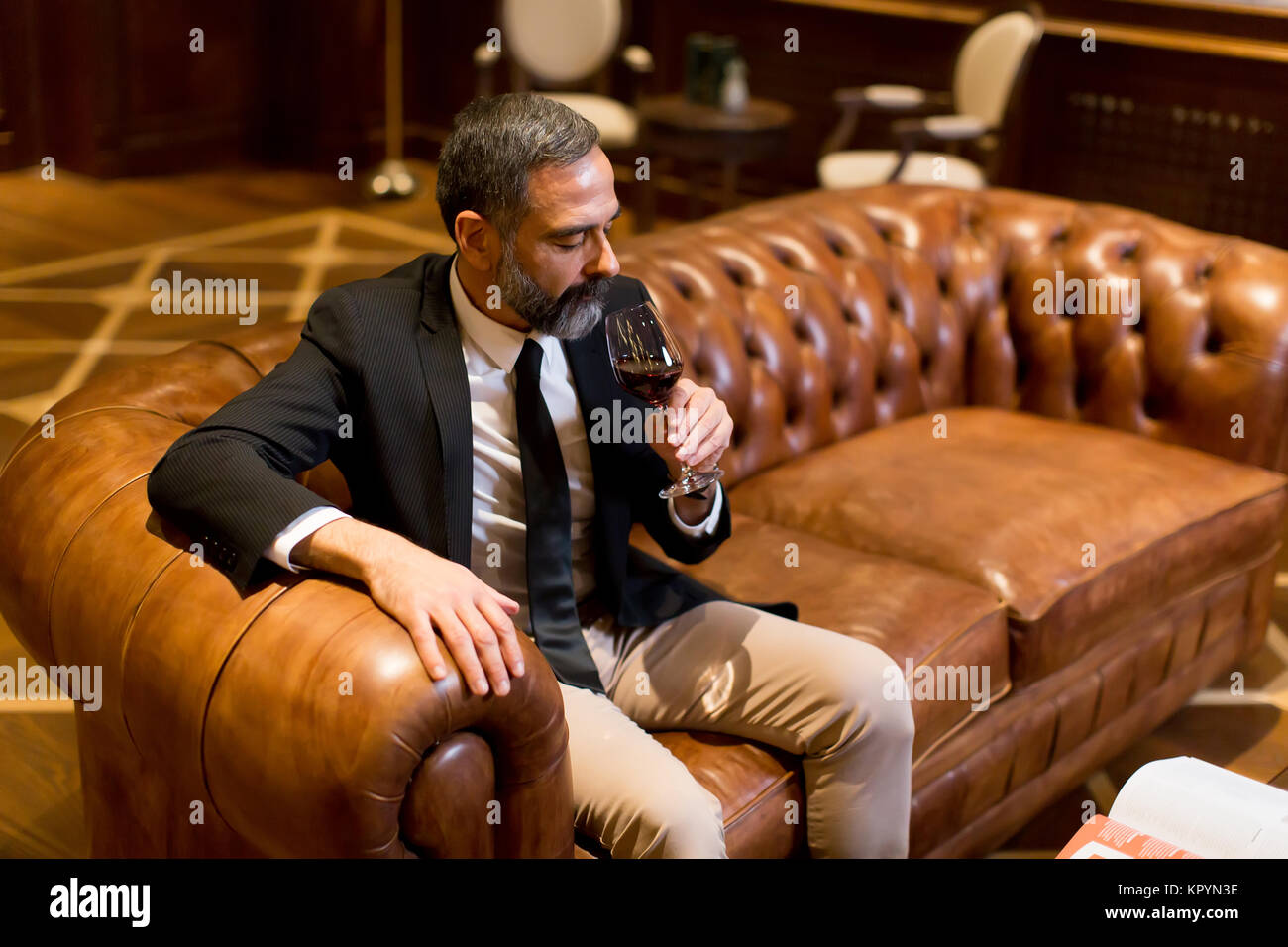 Beau elegant businessman drinking red wine in bar Banque D'Images